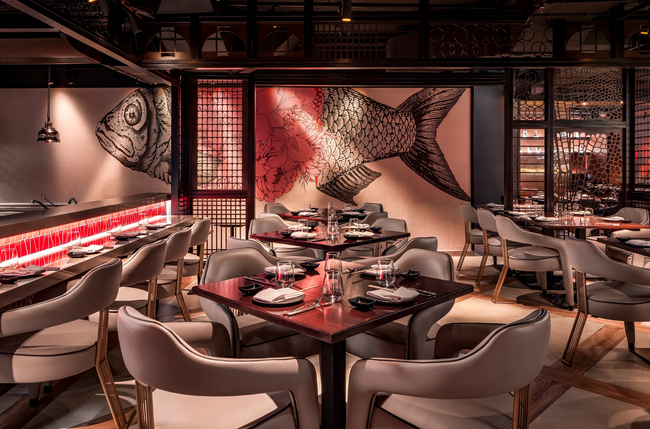 Restaurant dining room with a fish mural, red accents and rows of set tables