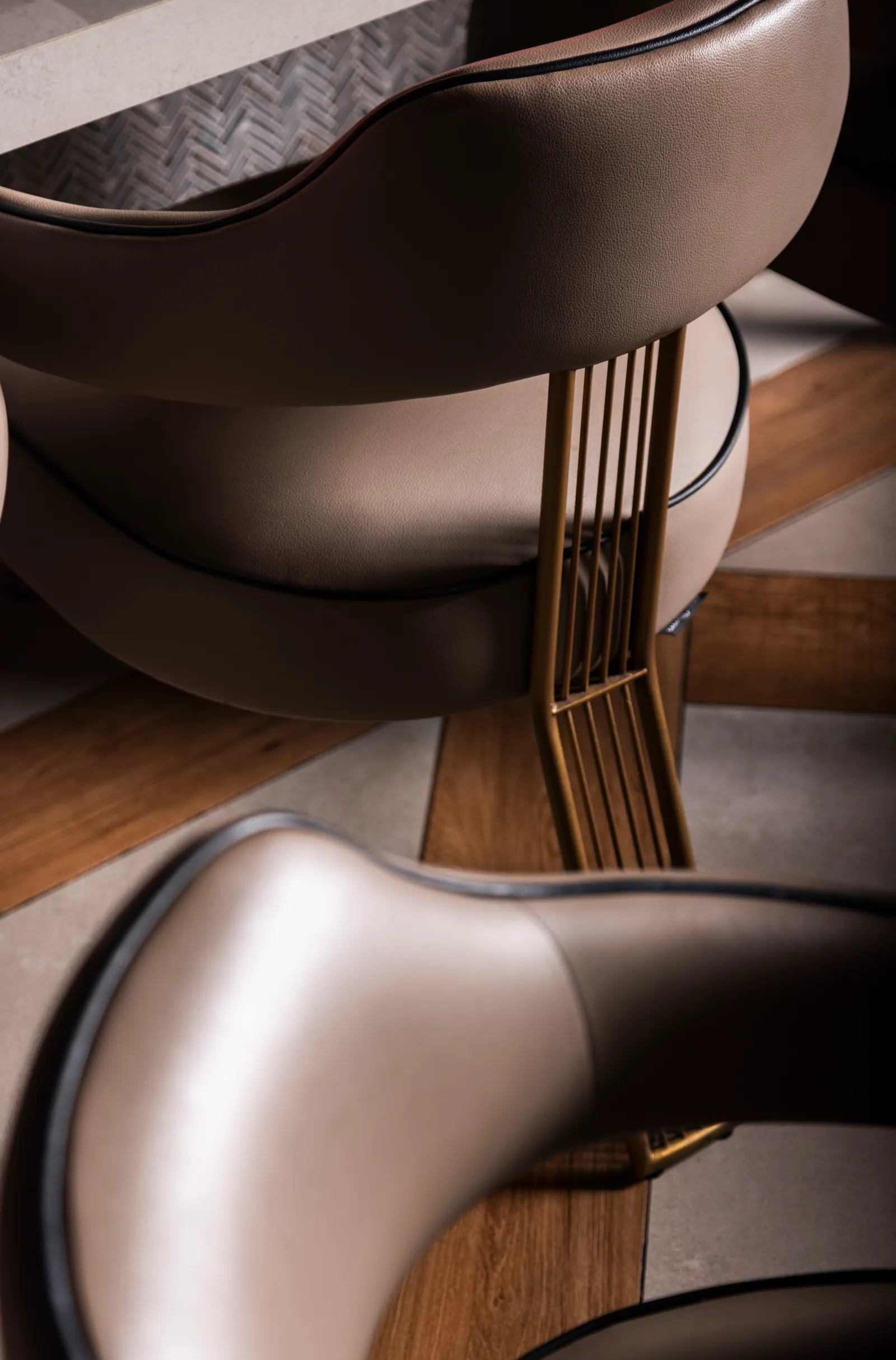 Close-up of curved leather dining chairs with metal trim