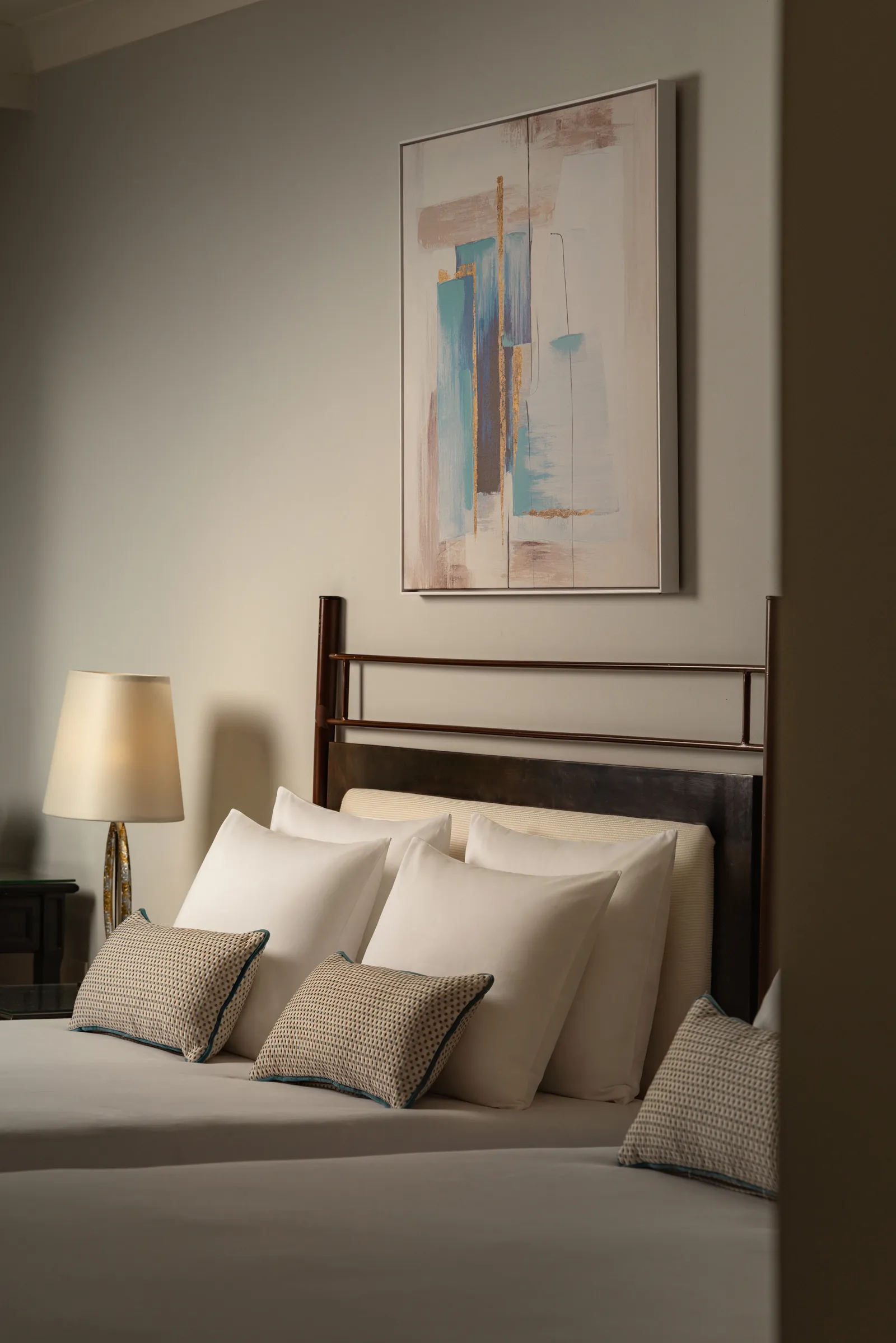 Double bed with abstract artwork above the headboard, Corinthia St George's Bay guest room