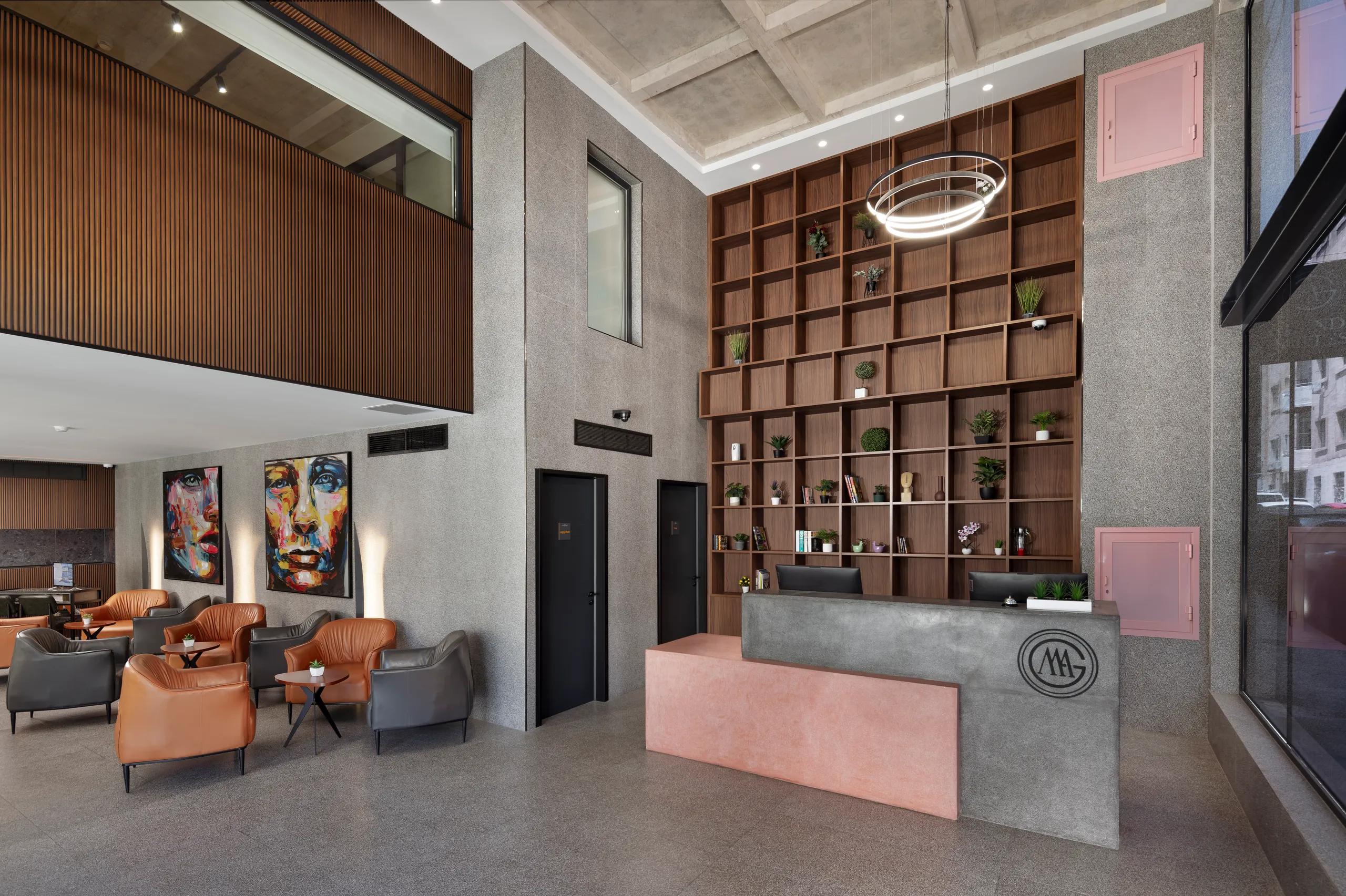 Hotel lobby with a concrete reception desk, shelving and seating areas