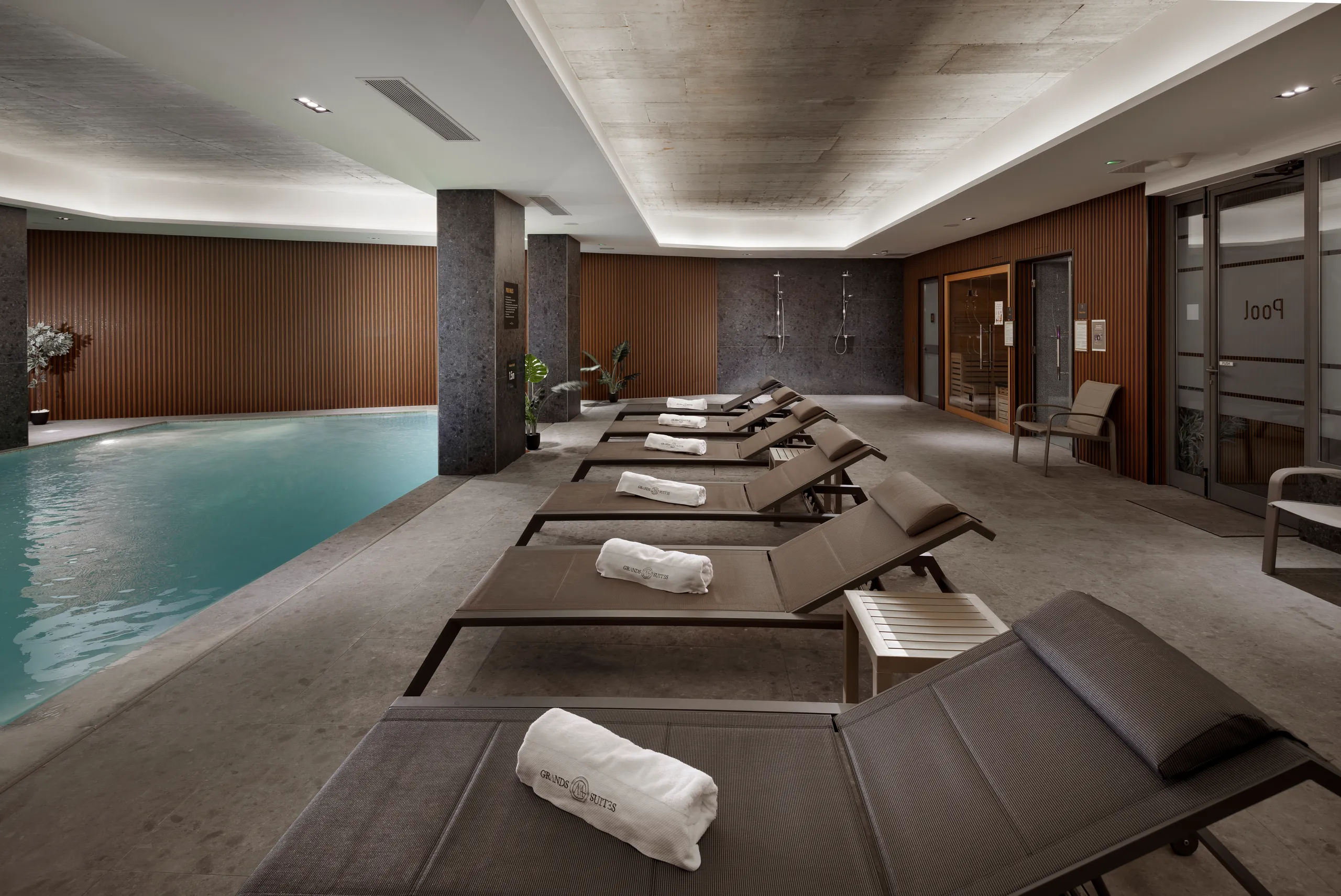 Indoor spa pool with sun loungers and rolled towels