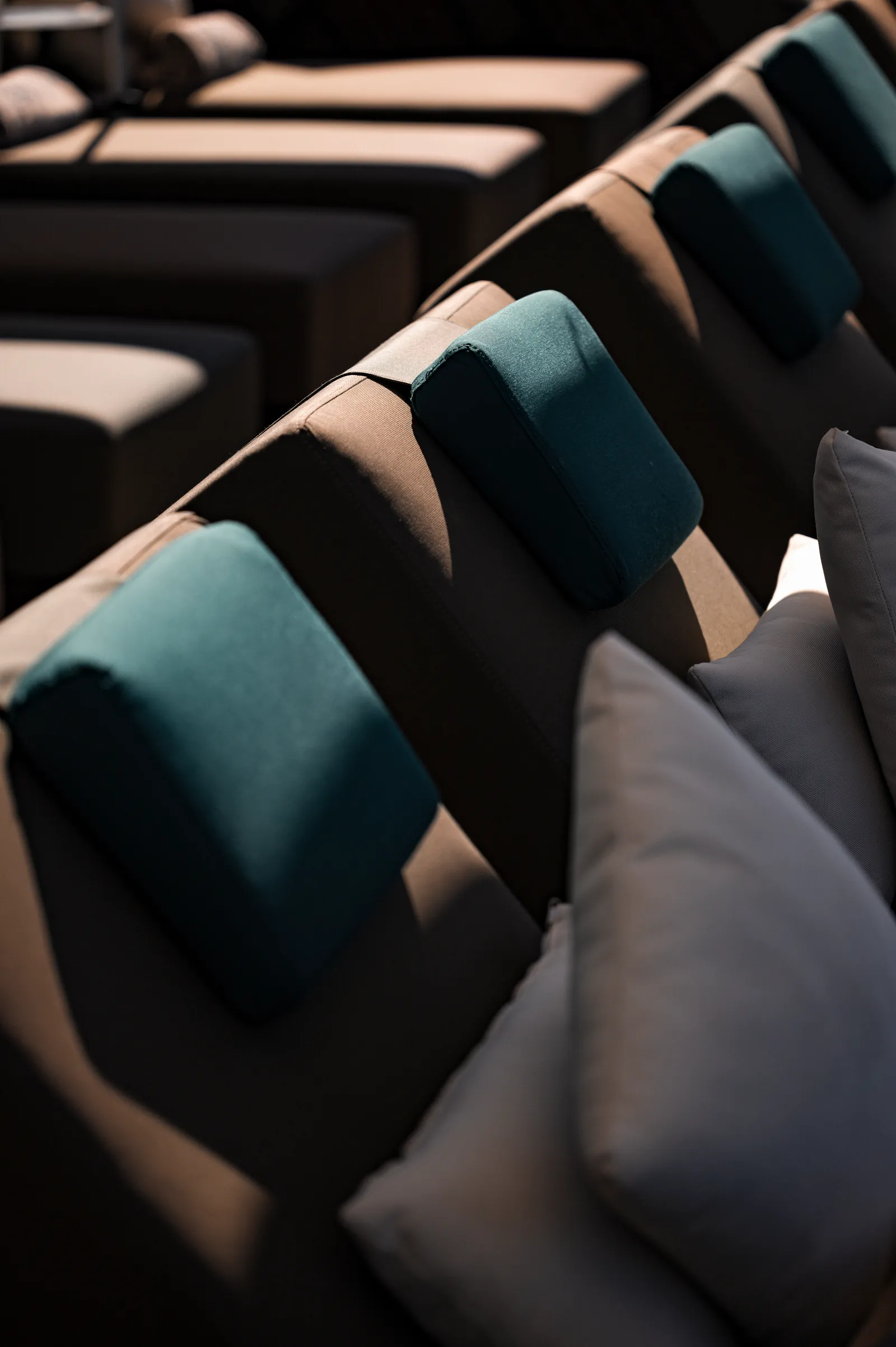 Sun loungers with teal and grey cushions in a row