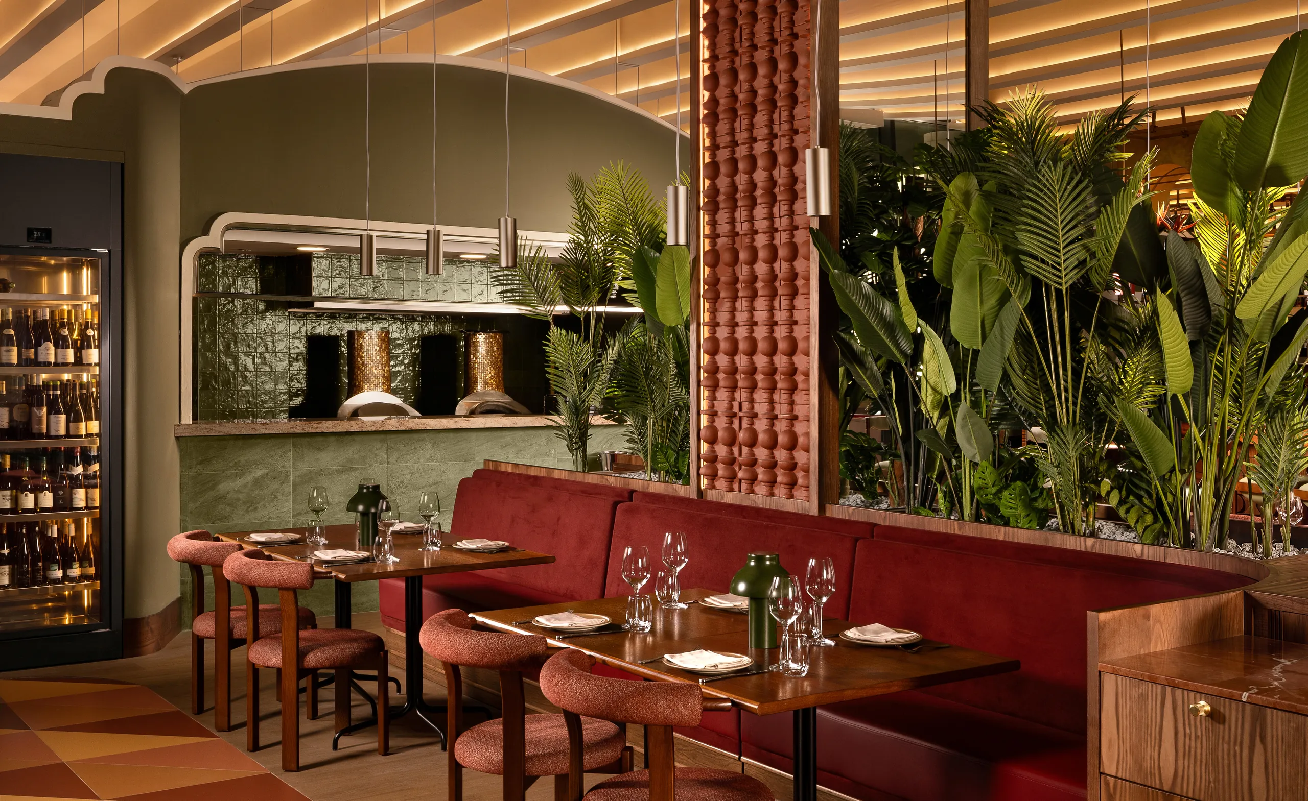 Tanvi dining room with red banquettes, terracotta tiles and an open kitchen with copper ovens