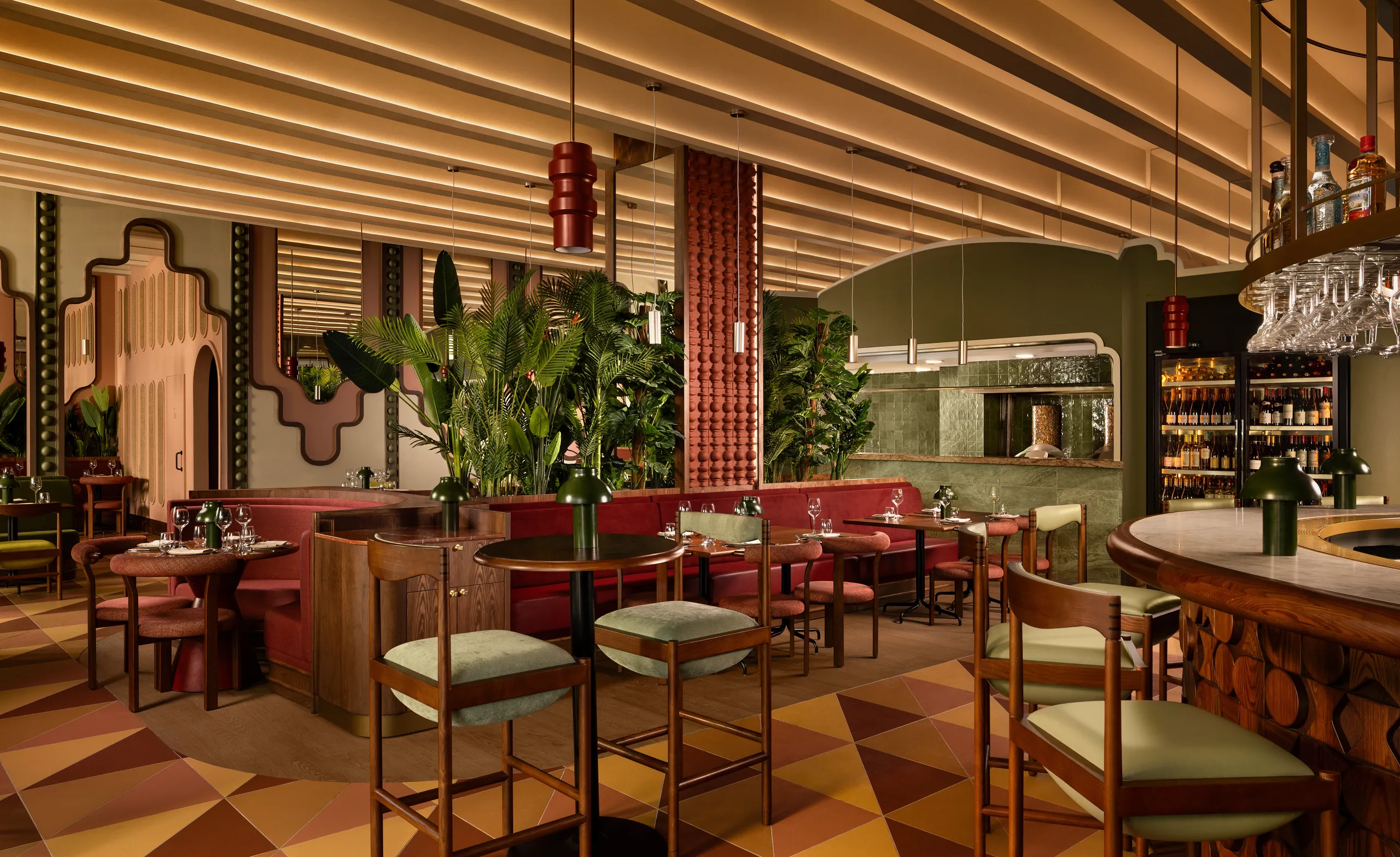 Tanvi bar and dining area with a geometric floor, red pendant light and lush plants