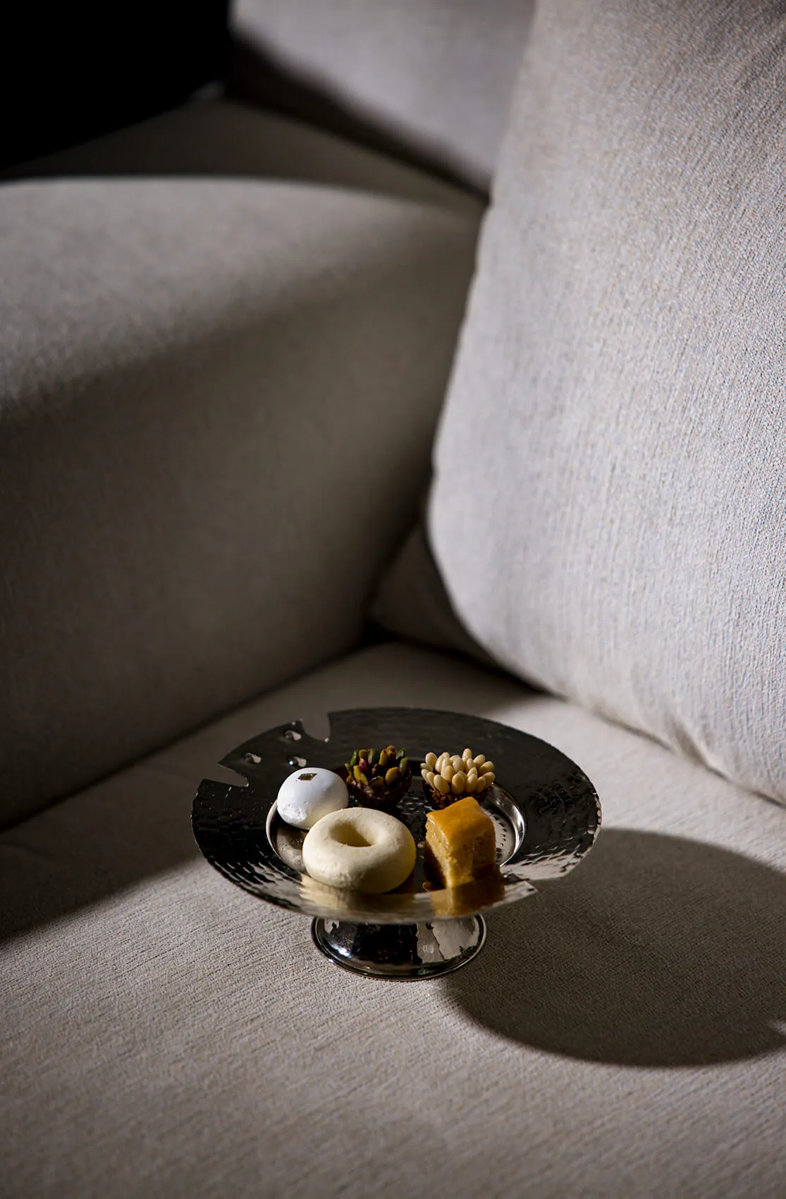 Small plated starter on a table beside a cream upholstered seat