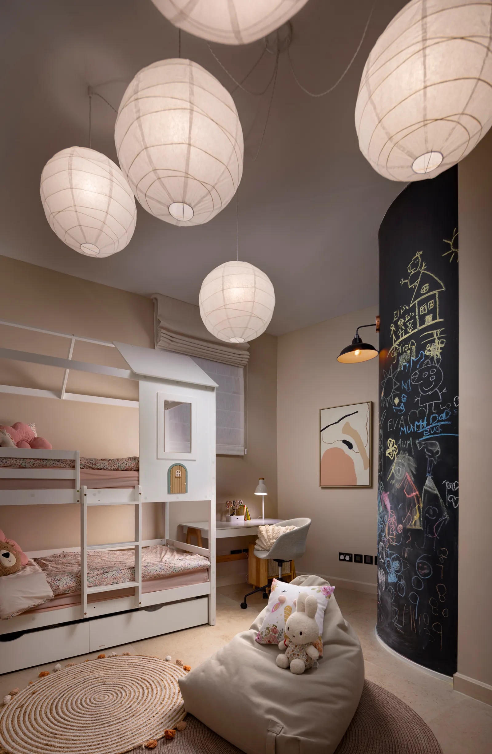 Children's room with bunk beds, paper lanterns and a chalkboard wall