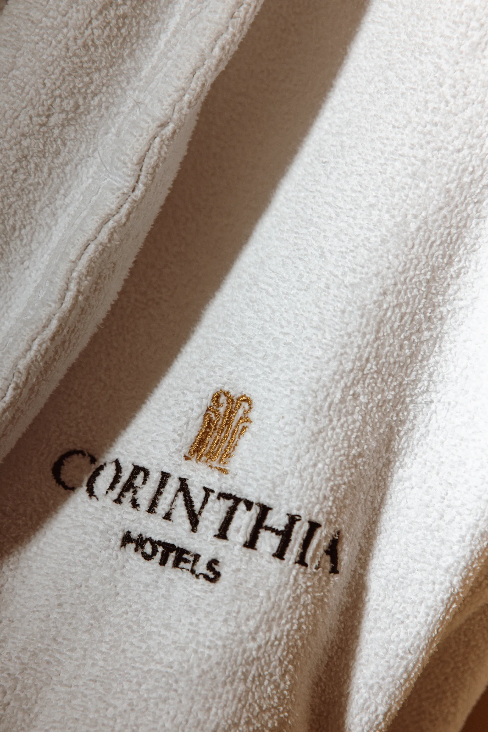 Corinthia Hotels logo on a white bathrobe