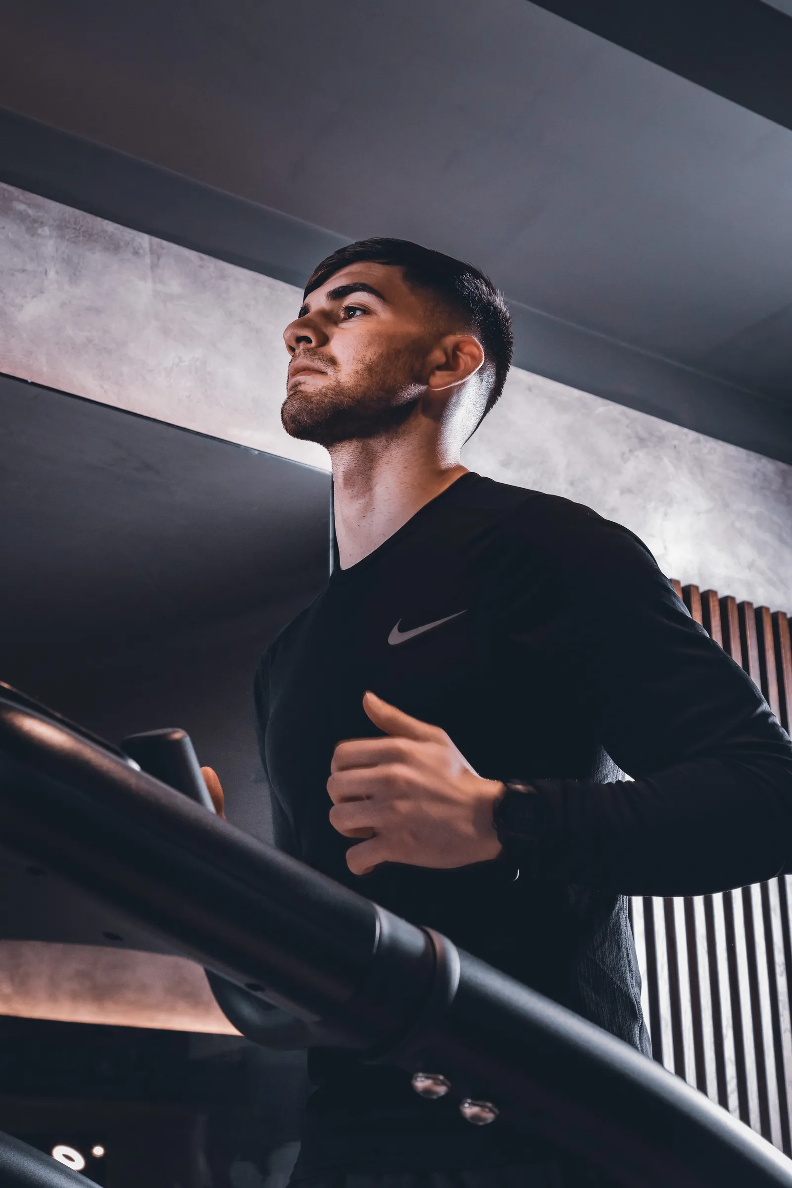 Man in a black training top on a staircase, seen from below