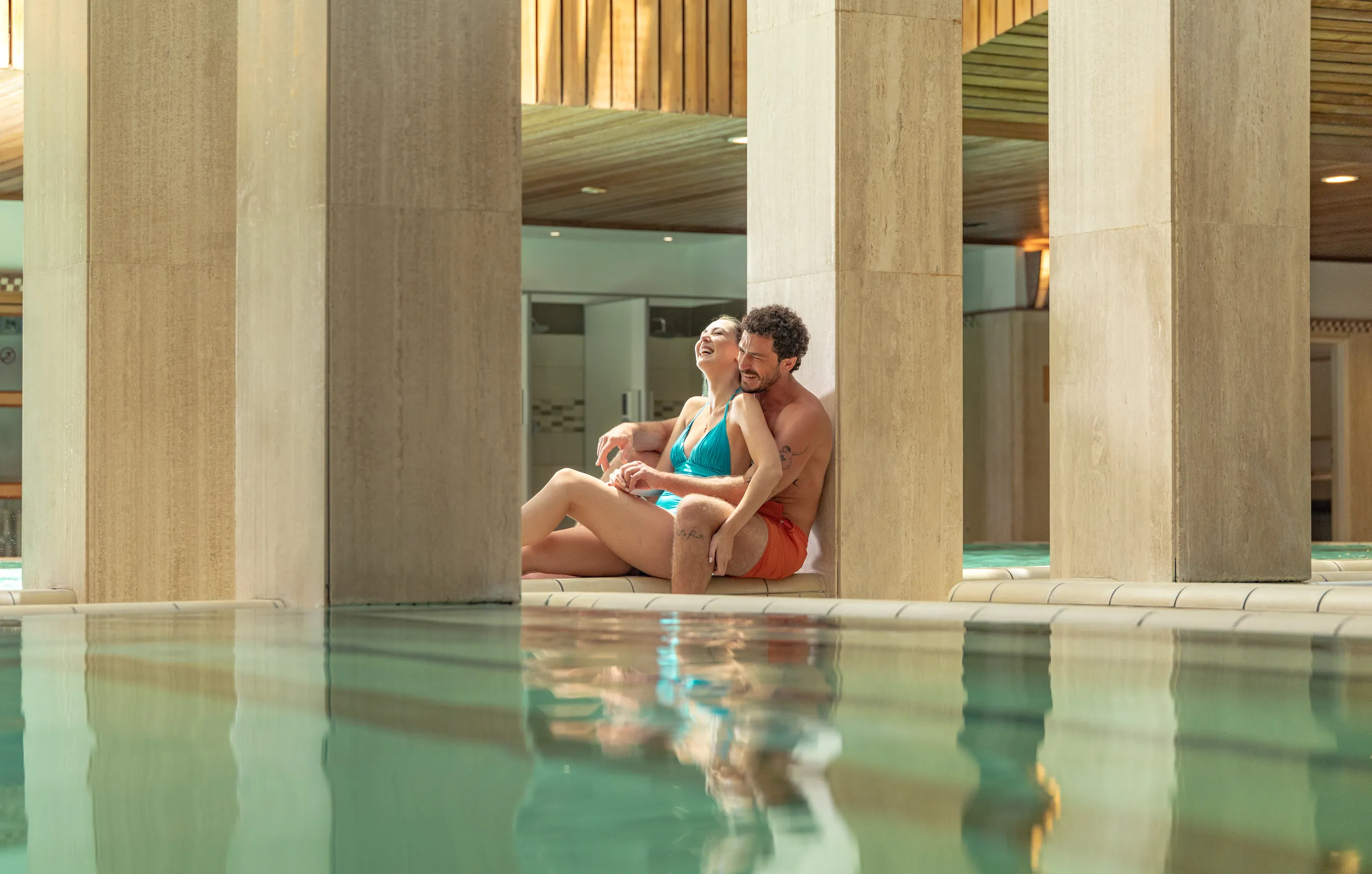 Couple relaxing beside the indoor pool of a hotel in Budapest