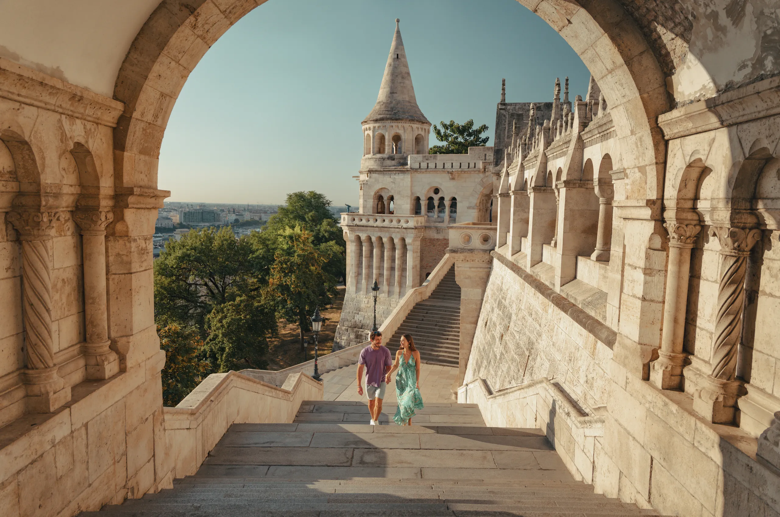 Couple walking through a stone archway at Fisherman’s Bastion in Budapest