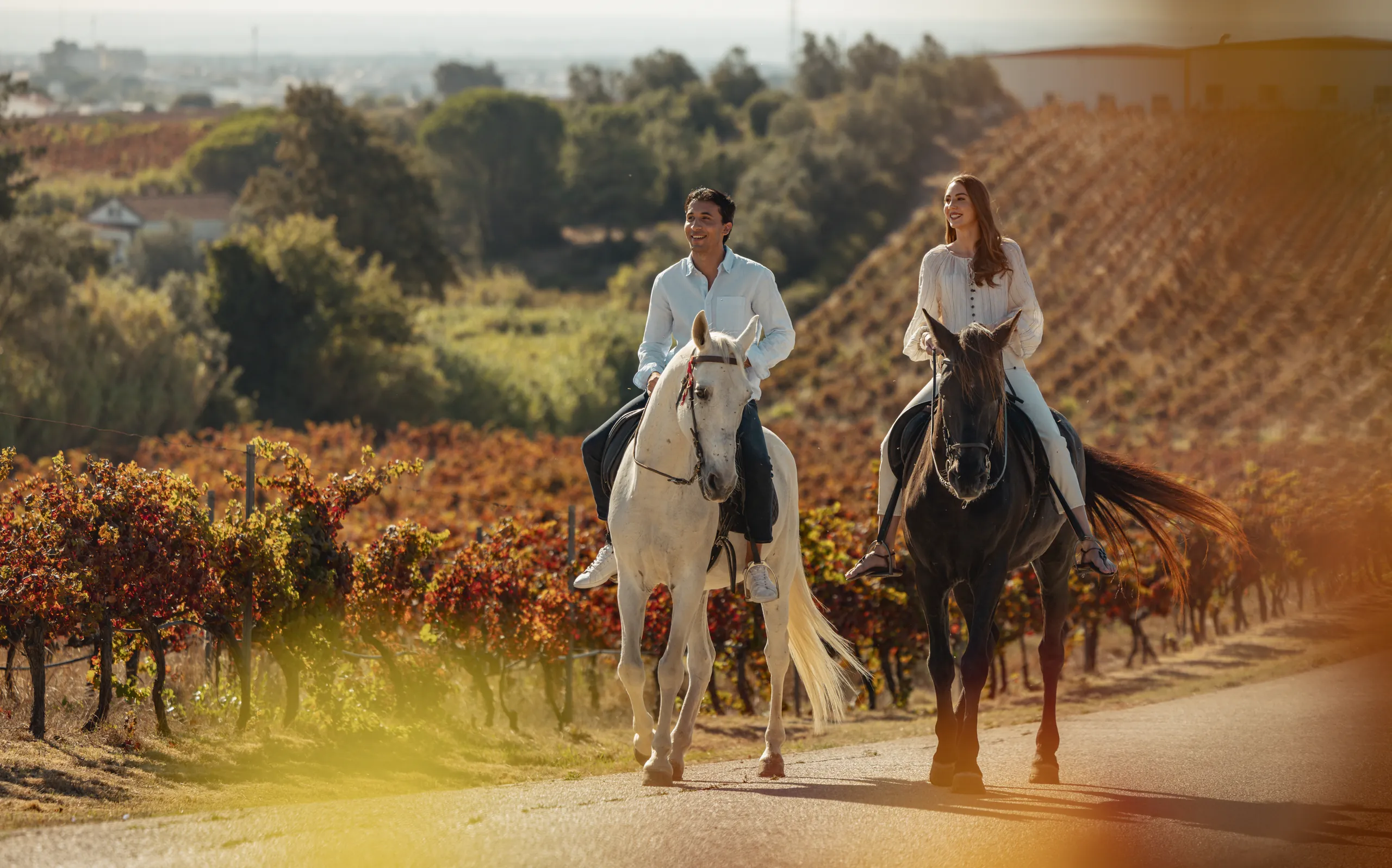 Two guests on horseback riding through a vineyard in Portugal, lifestyle photography for Verdi Hotels, part of Corinthia Group