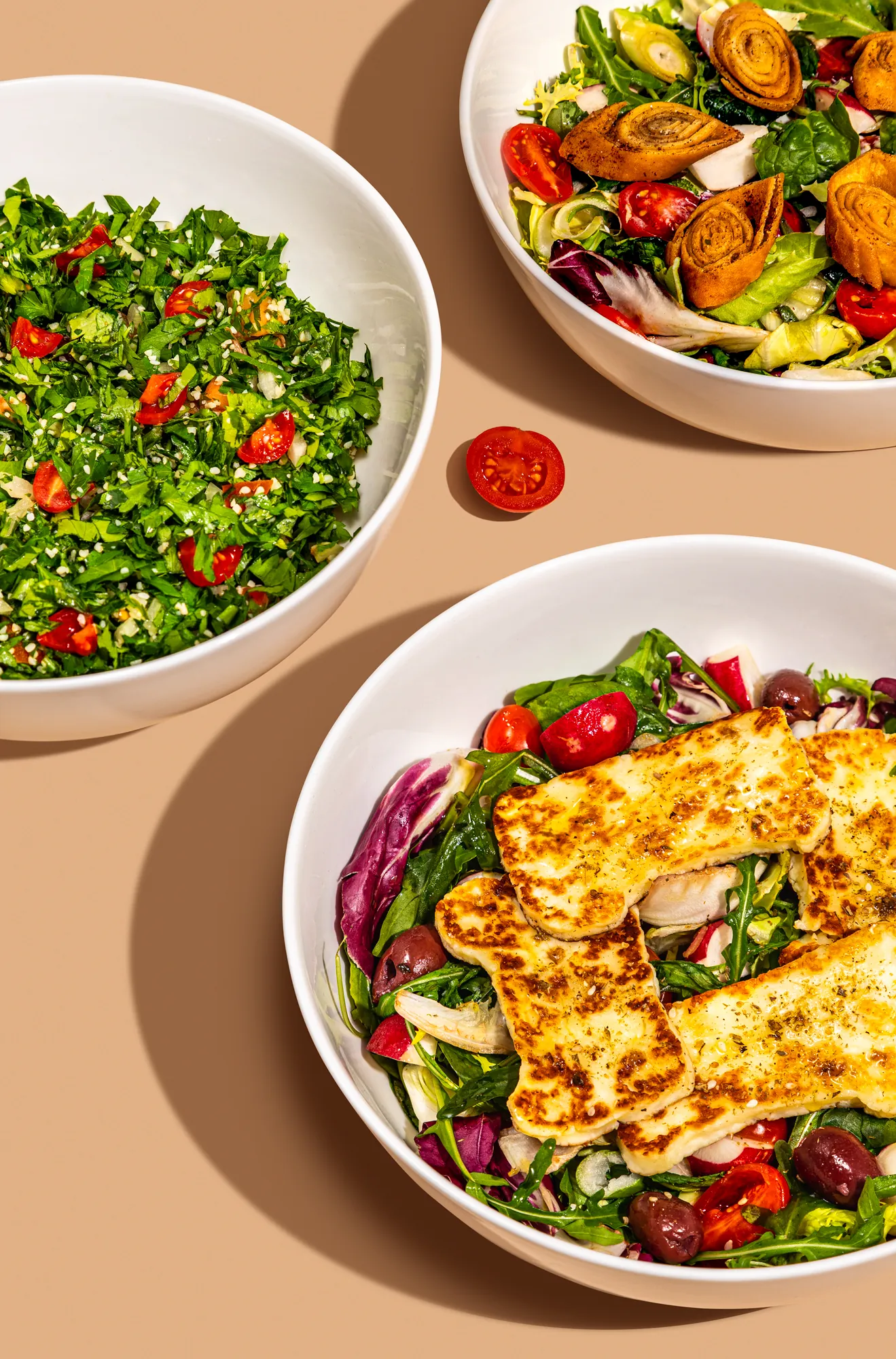 Tabbouleh and salads in white bowls on tan, for Baba Lebanese Street Food