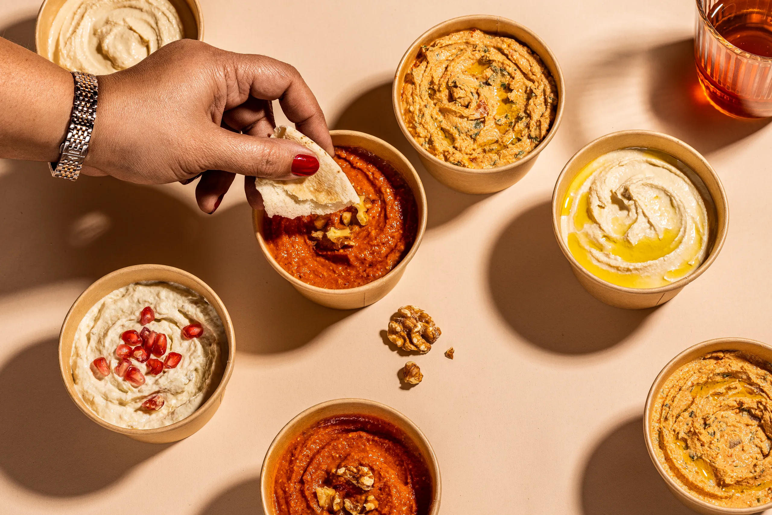 Hummus and muhammara dips in takeaway pots with a hand dipping pita, for Baba Lebanese Street Food