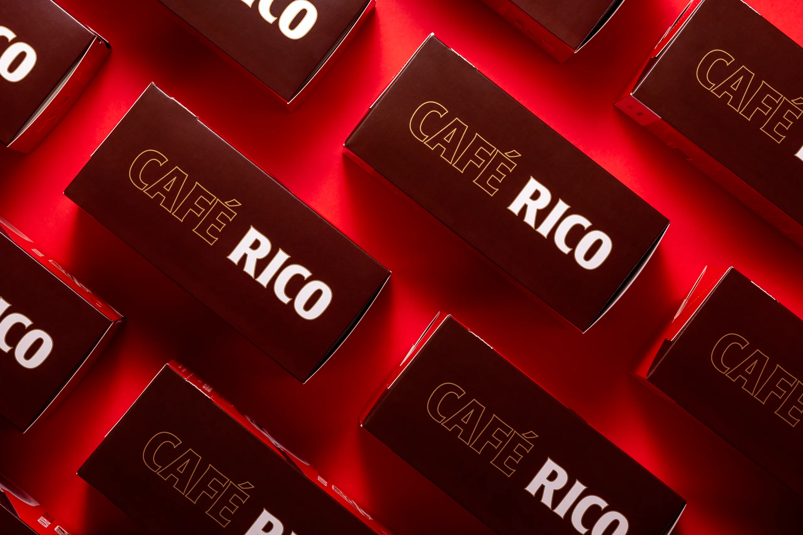 Dark brown Café Rico boxes in diagonal rows with gold outlined lettering, packaging photography