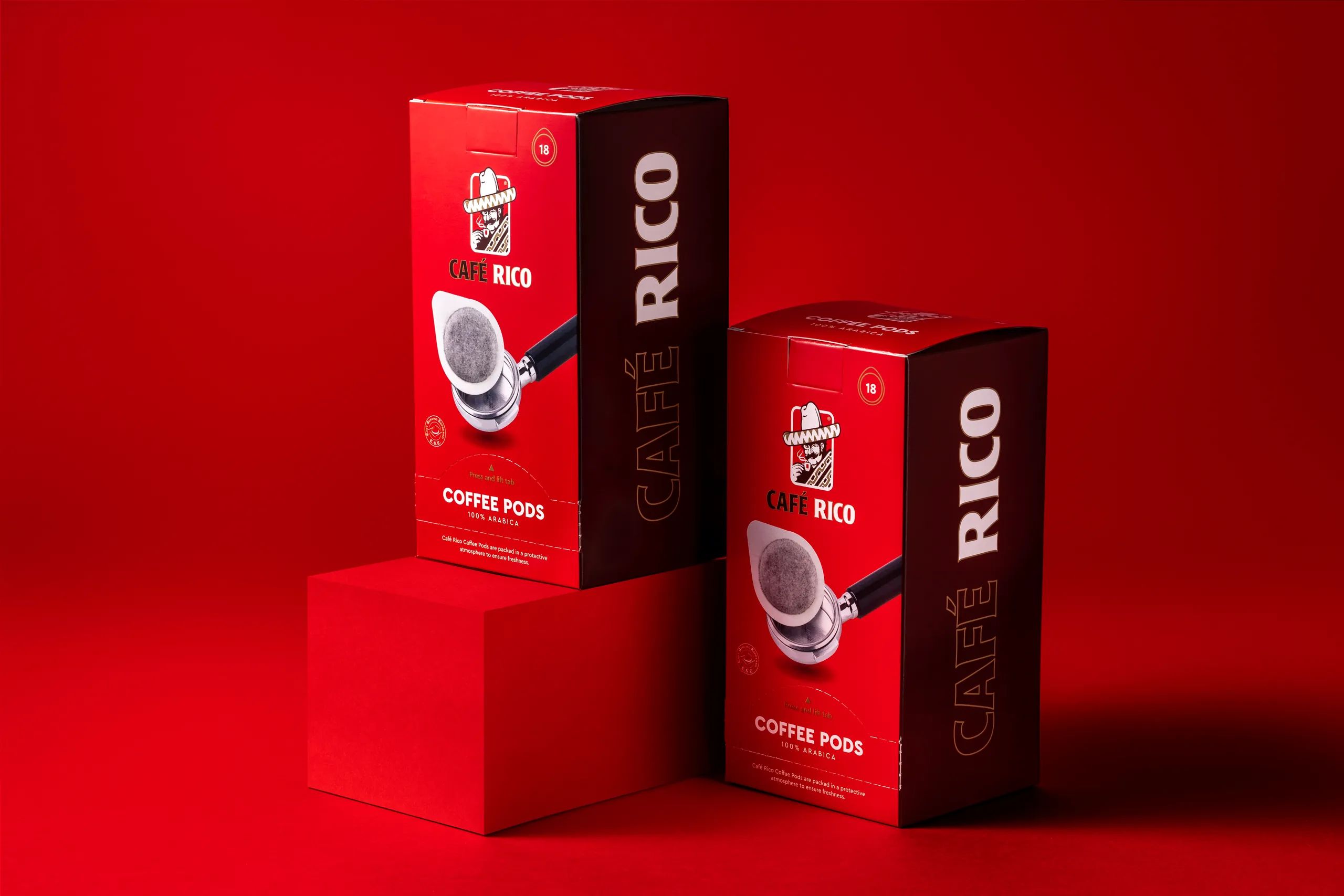 Two Café Rico coffee pod boxes stacked on a red block, packaging photography
