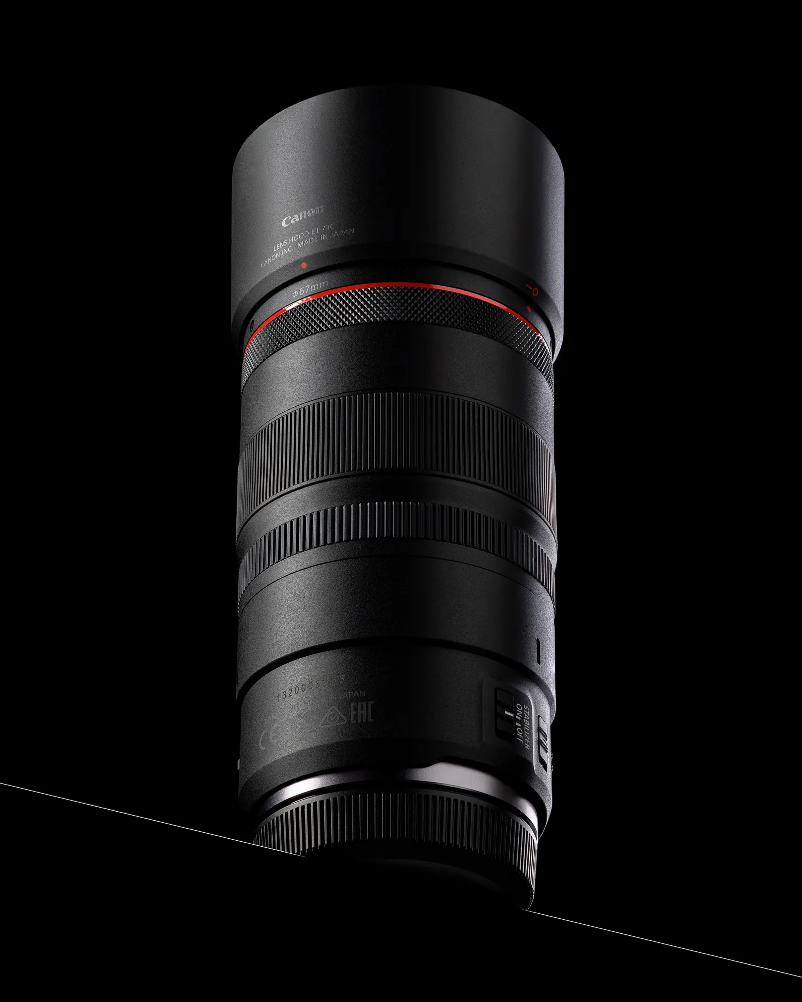 Black camera lens standing on a black reflective surface