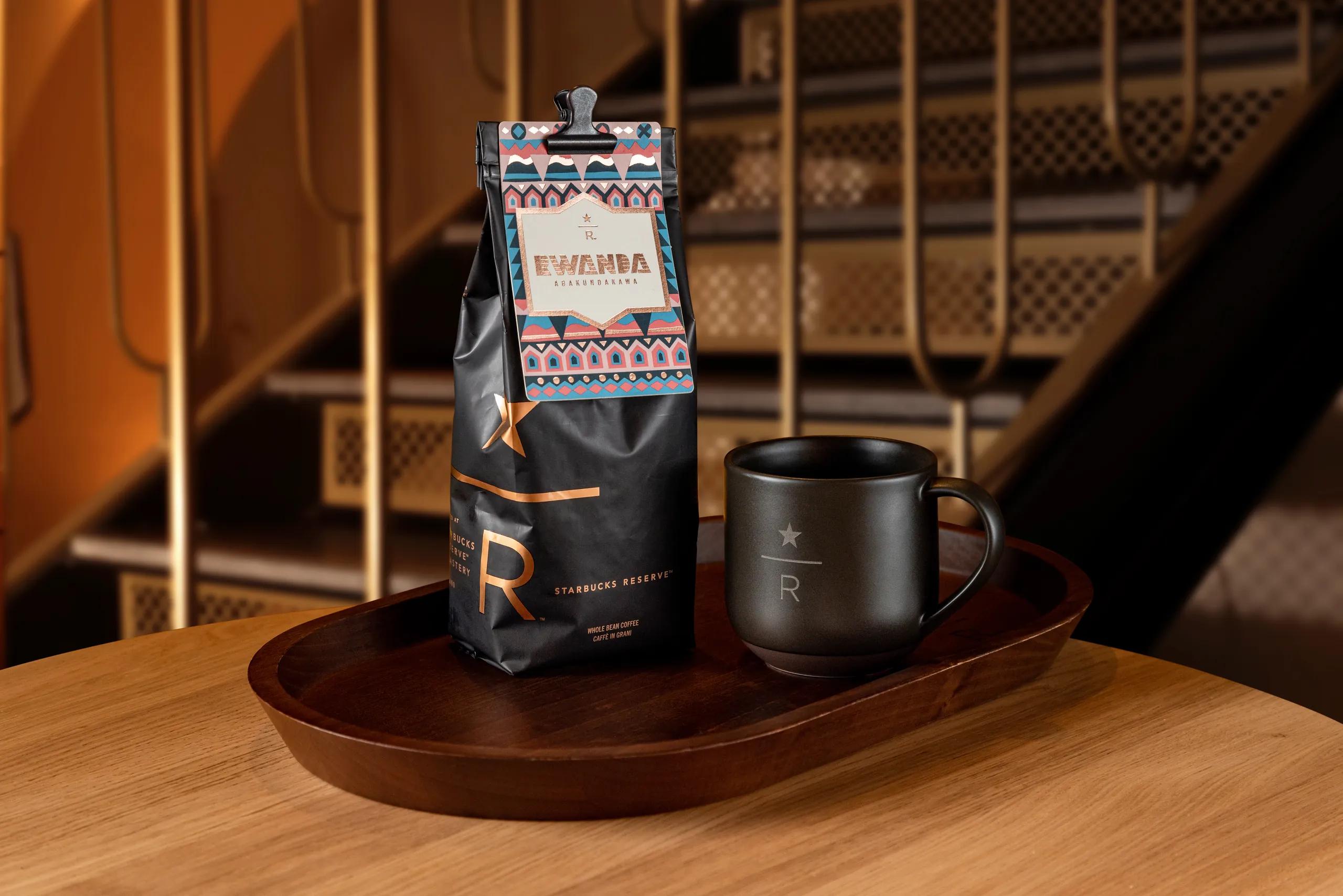 Bag of Starbucks Reserve coffee beans beside a black mug on a wooden table