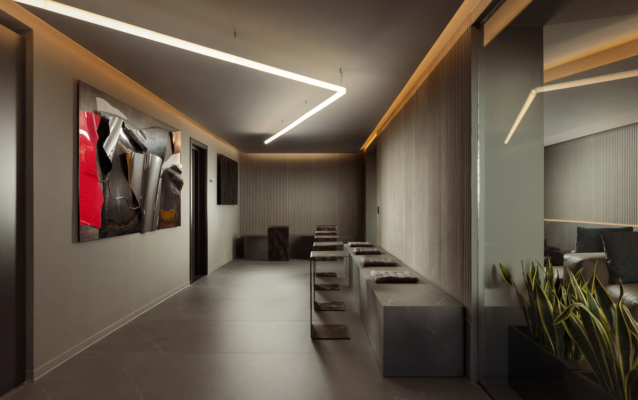 Entrance hall of a boutique hotel with a red artwork and a linear ceiling light