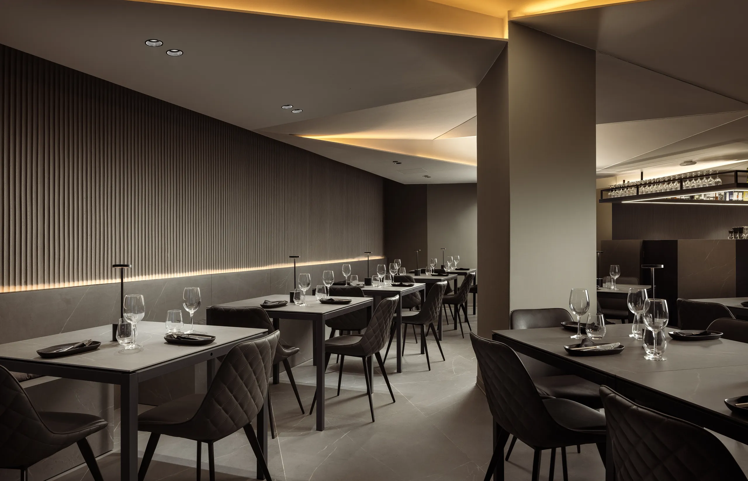 Hotel restaurant with set tables, grey chairs and a slatted wall